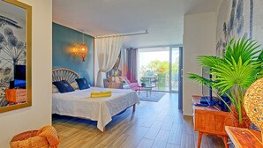 A bedroom with a bed, a bedside table, a mirror, a window, and a balcony with outdoor furniture. - Studio in Anse Marcel, beach, air conditioning, parking (Saint-Martin)