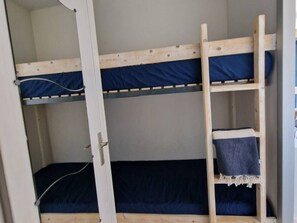 A bunk bed with a ladder and a single bed below. - Charming 2-Room Apartment with Pool, Terrace, and A/C - 4 Sleeps - Near Port and Beach (Port Camargue)