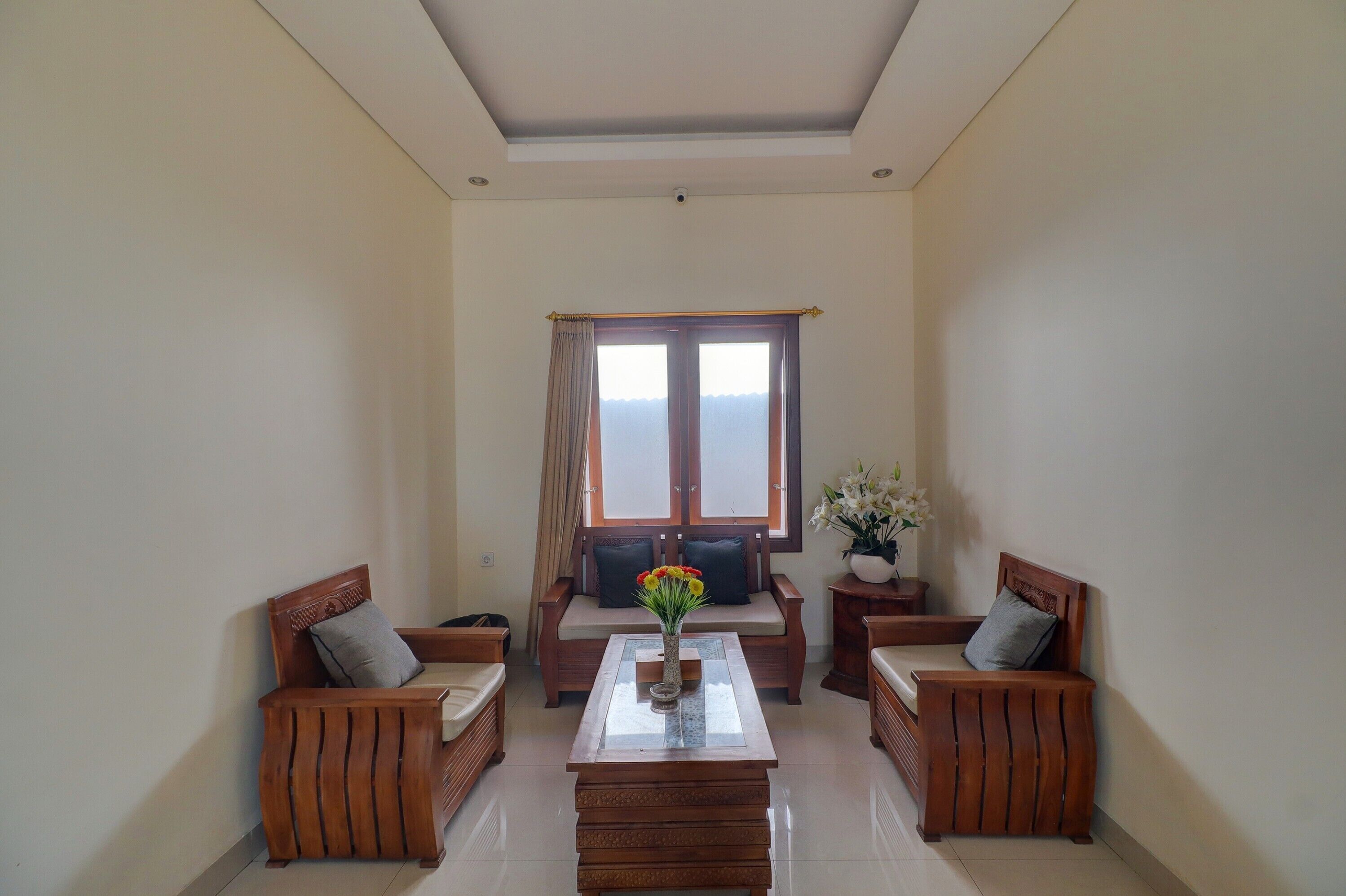 A living room with a sofa set, a coffee table, and a window with curtains.