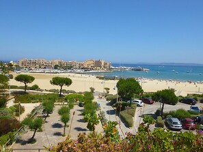 Enjoy ocean views from your room's balcony, with the beach and boats in the background.