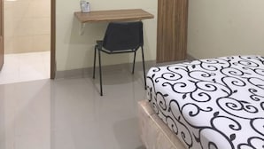 A bedroom with a bed, a desk, and a chair. - OYO Life 92779 Kost Arjuna (Tangerang)