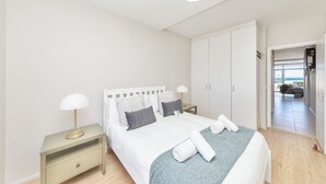 A modern bedroom with a bed, nightstand, and wardrobe. - Dolphin Beach CG12, Blouberg by HMH (Cape Town)