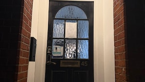 A black door with a white sign above it reading "45 ROMFORD ROAD".