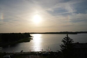 A river with a bridge in the foreground and a sunset in the background. - APARTAMENTY NA WZGÓRZU (Insko)