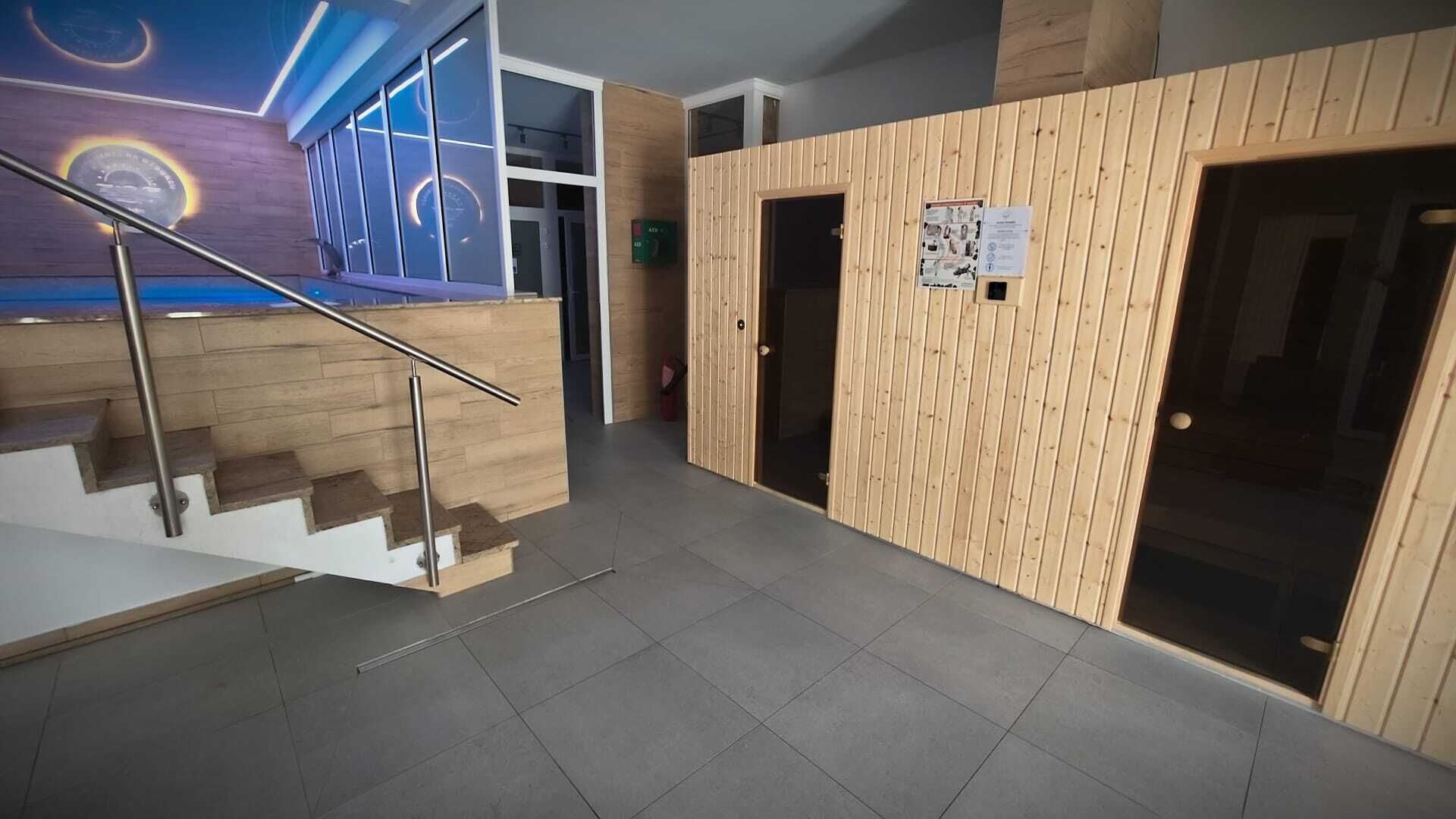A modern interior with a staircase, wooden panel walls, and a tiled floor.