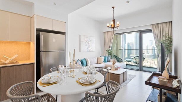 A modern living room with a dining area, large windows, and a view of the city.