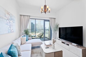 Comfort Apartment | Living area | 55-inch Smart TV with cable channels - Nasma Holiday Homes - Burj Royale (Dubai)
