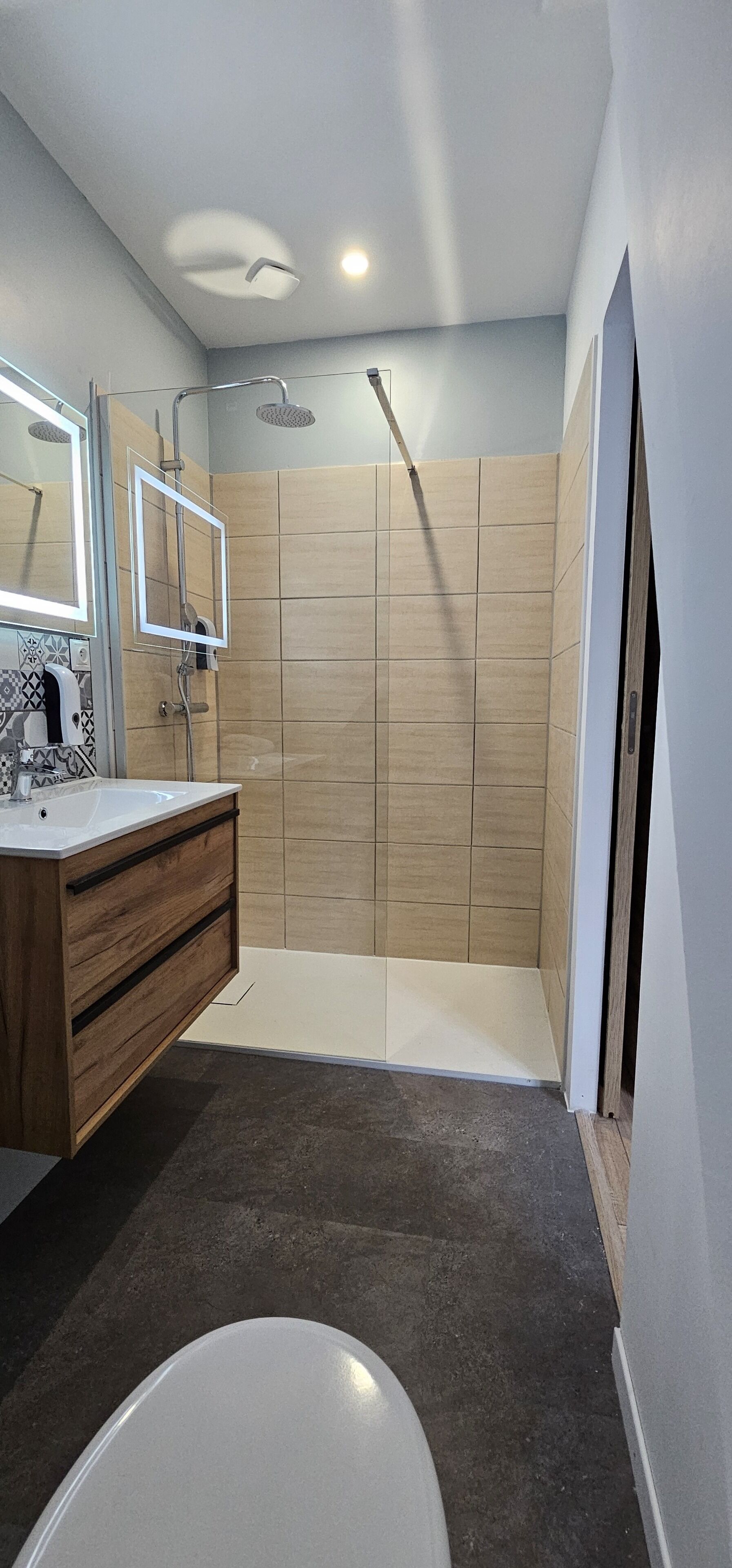 Een moderne badkamer met een douche, een wastafel met spiegel en een bad.