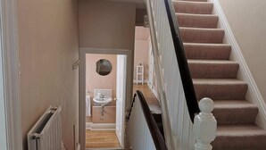 A staircase with carpeted steps and a white balustrade.