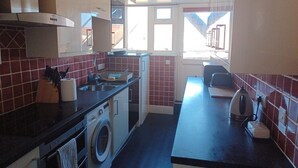 A compact kitchen with a washing machine, a sink, and a toaster. - 25 Avenue Victoria, Flat 2 (Scarborough)