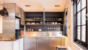 Una cocina moderna con electrodomésticos de acero inoxidable, horno empotrado y ventana que proporciona luz natural.
