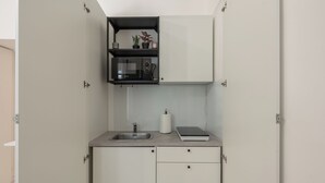 Eine kleine Küche mit eingebauter Mikrowelle, Spüle und einer Arbeitsplatte.