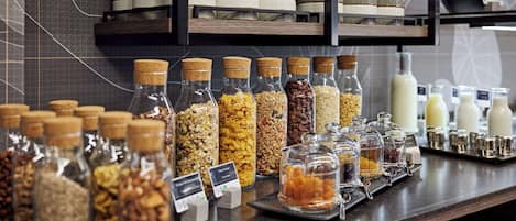 A buffet area with various food items in jars and containers, including nuts and grains.