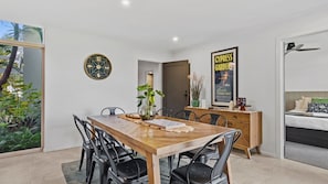 A modern dining area with a wooden table, black chairs, and a decorative clock. - Yarrawonga Lakeside apartment 43 -  3 Bedrooms (Mulwala)