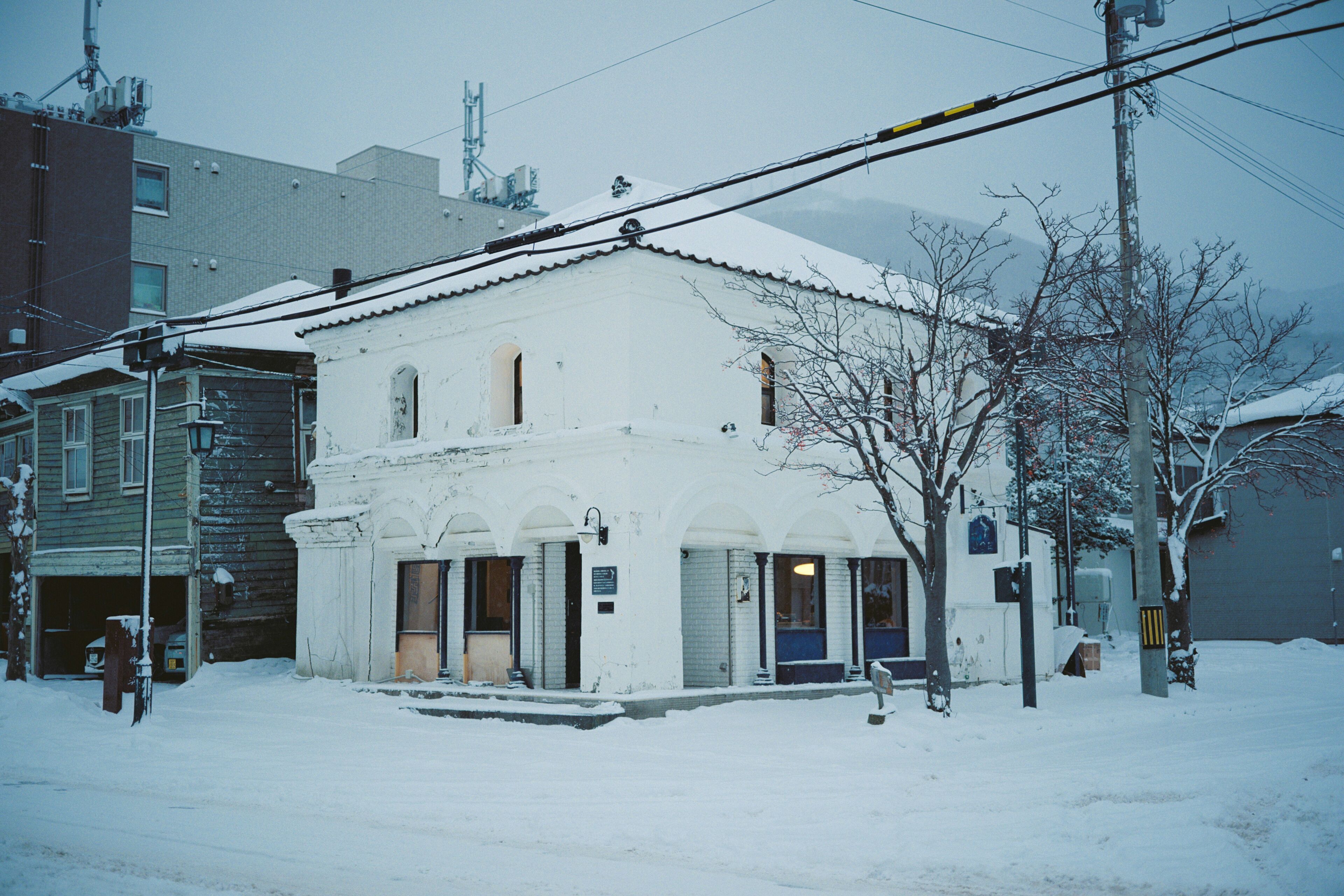 A snow-covered building with a white facade and multiple windows.