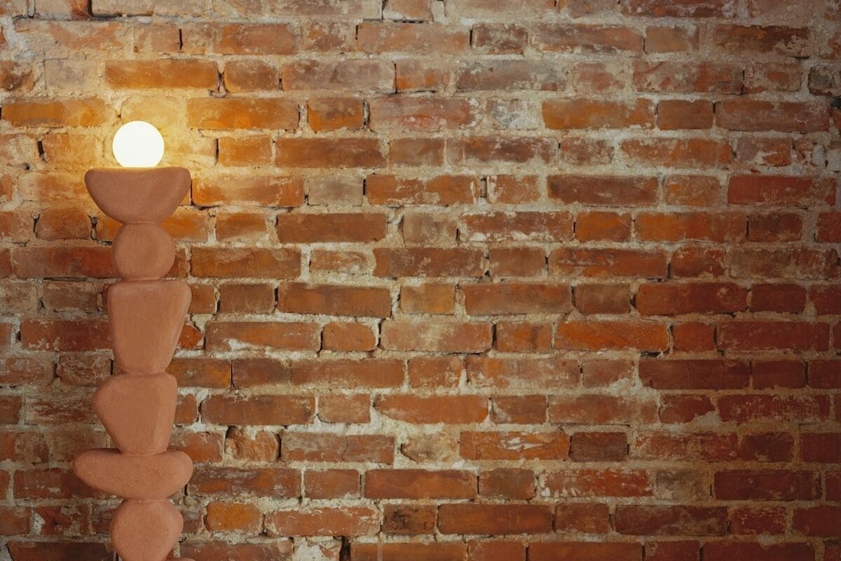 A brick wall with a hanging light fixture.