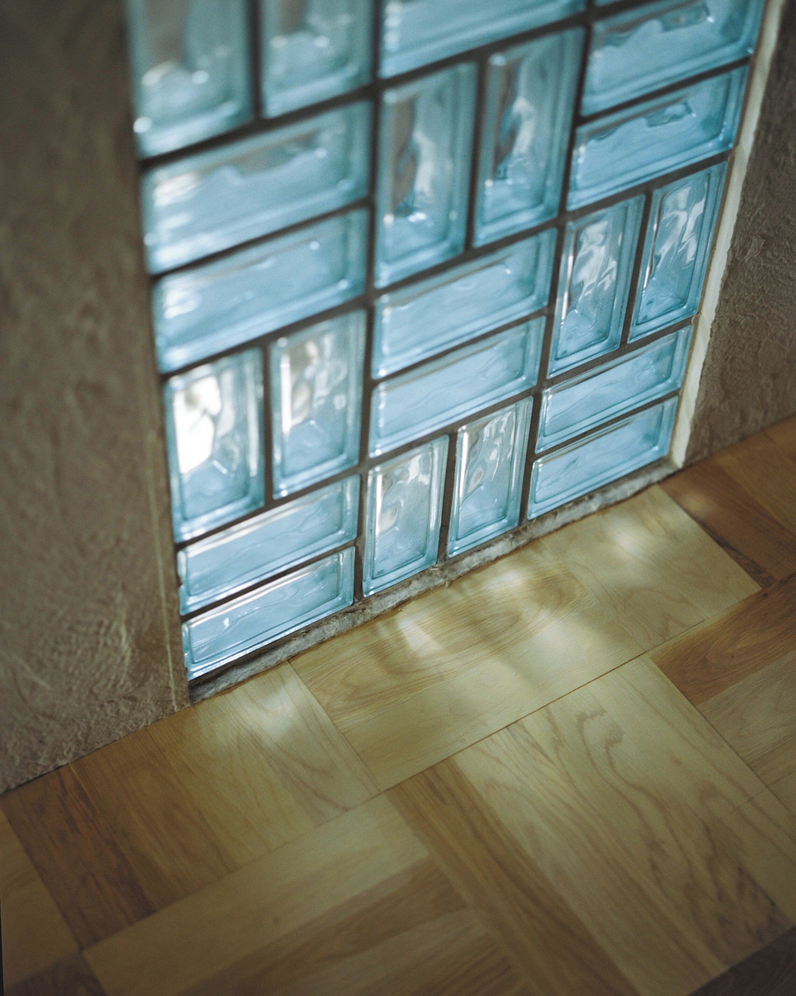 A tiled wall with a wooden floor.