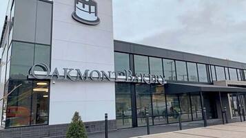 A modern building with a large sign reading "CARMONE BAKERY".