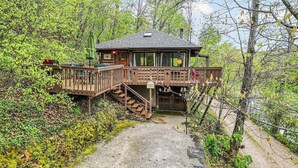 Een houten chalet met een terras en een trap naar een overdekte ingang.
