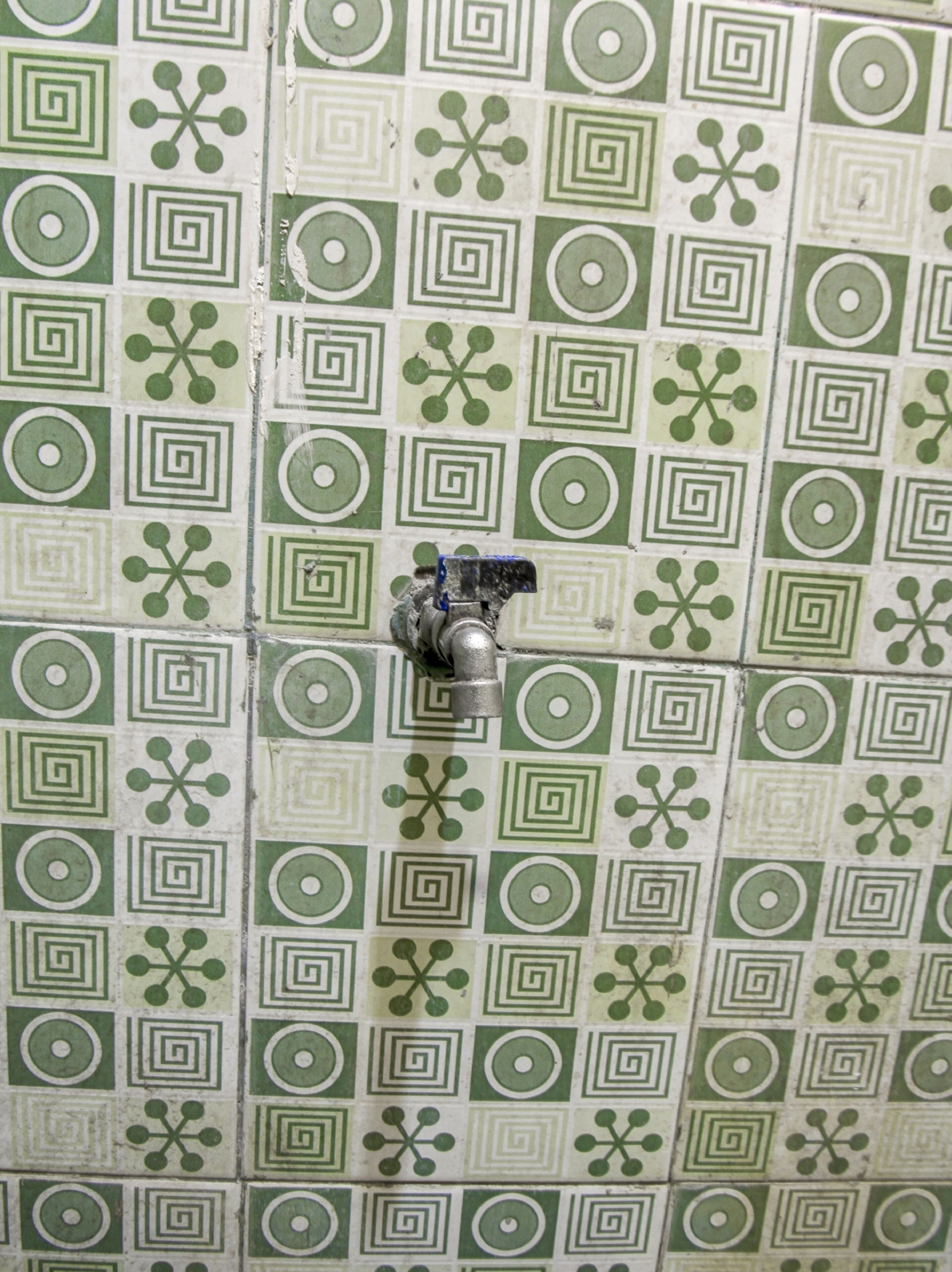 Una pared de azulejos con un diseño geométrico verde y blanco.