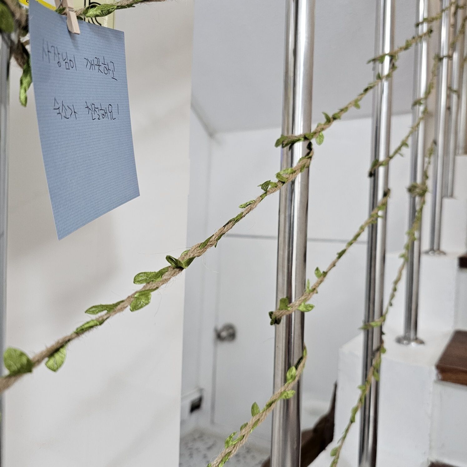 A room with a metal pole and a string of green vines.