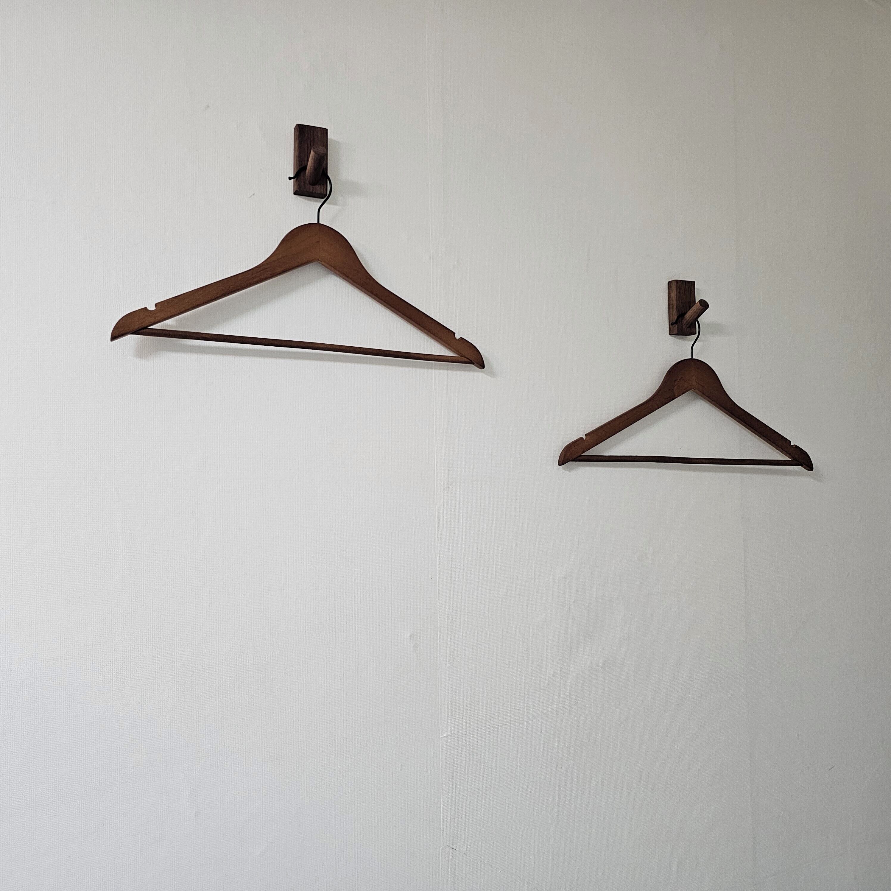 Dos perchas de madera fijadas a la pared.