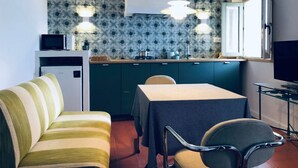 Une petite cuisine équipée d’un four à micro-ondes, d’un réfrigérateur et d’un coin repas avec une table et des chaises.