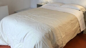 Une chambre à coucher avec un lit, une table de chevet, une lampe et un escalier en bois.