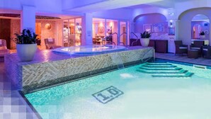 Ein Hallenbad mit Whirlpool, Liegestühlen und einer Rezeption.