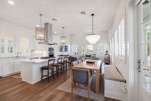 Cocina moderna con una isla central, comedor y asientos.