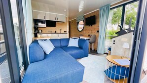 A modern interior with a sectional sofa, a kitchen area, and a dining table.
