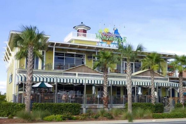 A multi-story building with a sign reading "Margaritaville" and palm trees in front.