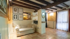 A cozy living room with a sofa, a television, and artwork on the walls. - Ca' Rielo (Venice)