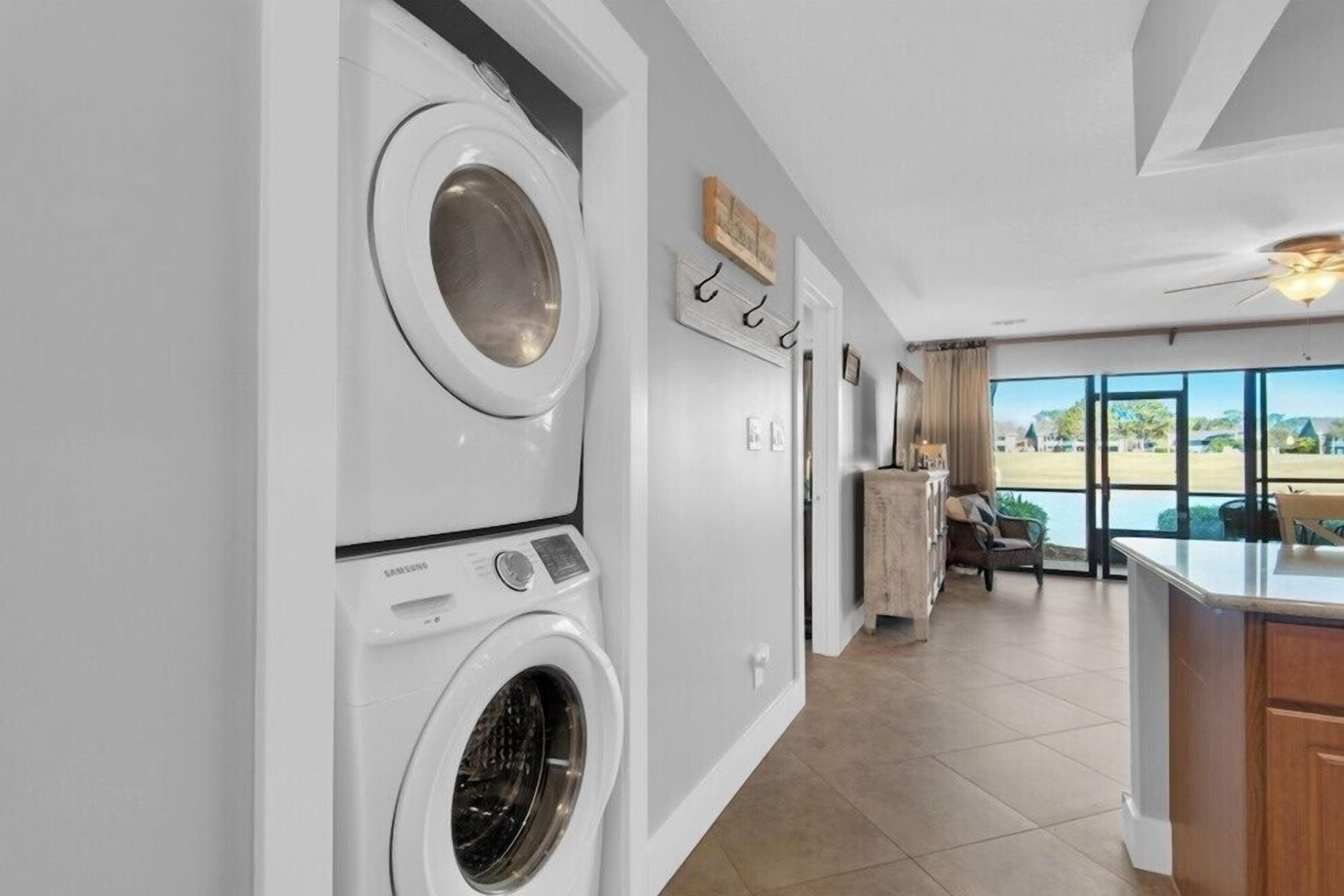 A laundry room with a Samsung washer and dryer, a dining area with a view of the beach, and a large window.