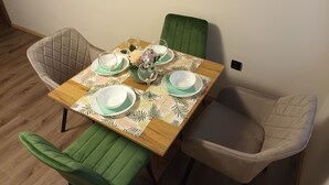 A dining table set with plates, glasses, and a vase of flowers.