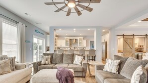 A spacious living room with a large sectional sofa, a fireplace, and a ceiling fan. - Private Beach & Deck: Bayfront Home in Hayes! (Hayes)