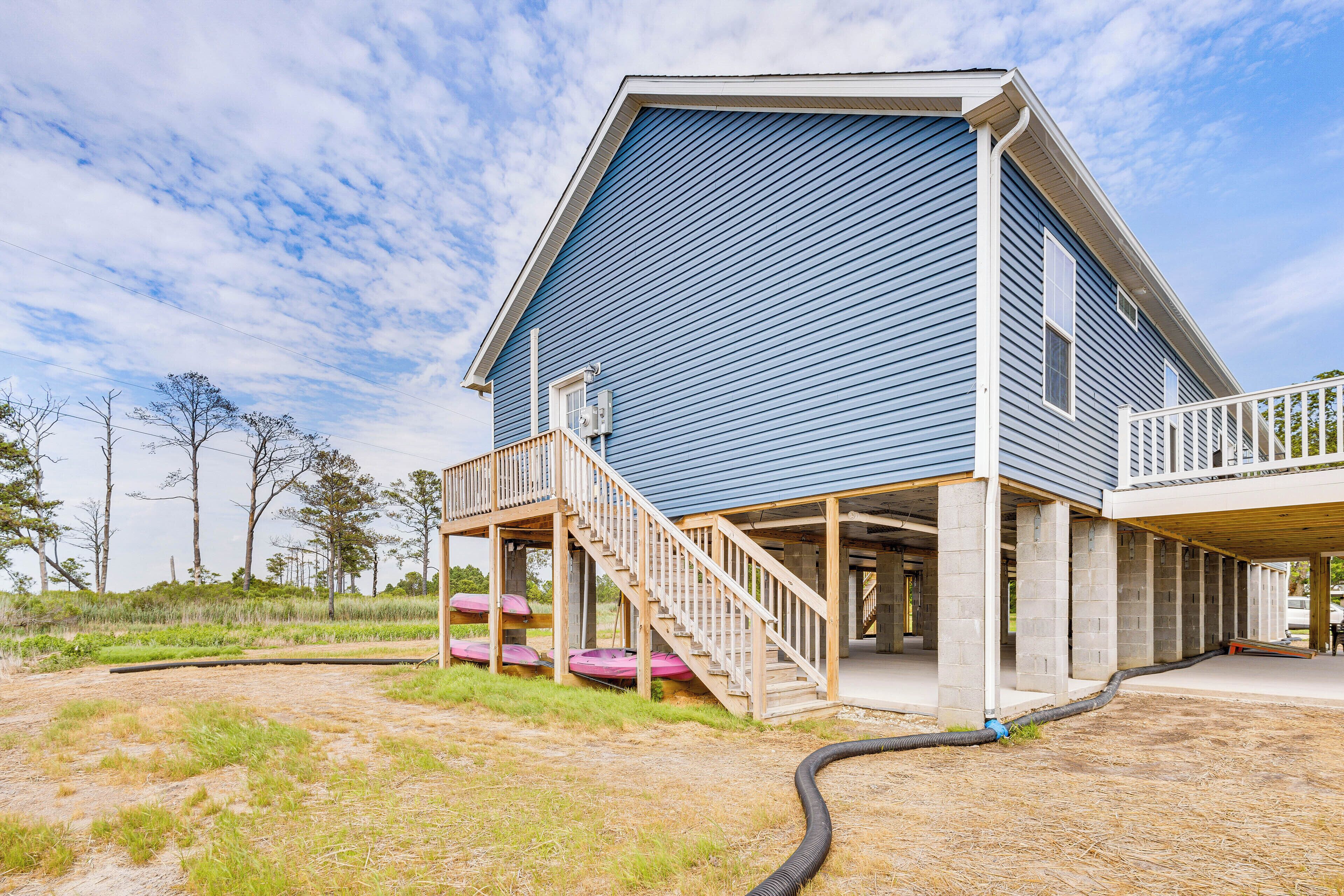 A two-story building with a blue exterior, a wooden deck, and a covered outdoor area.