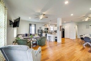 A spacious living area with a sofa, armchairs, a dining table, and a kitchen in the background. - 3 Mi to Dtwn: Updated Retreat in Indianapolis! (Indianapolis)