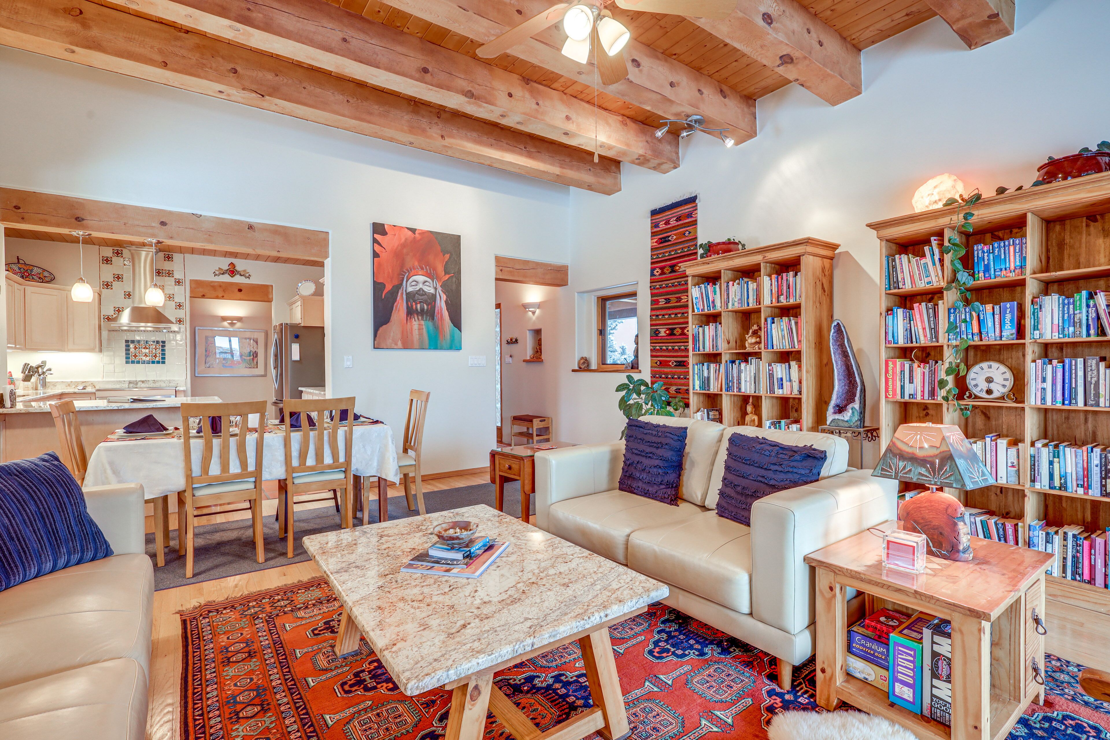 A cozy living room with a sofa, coffee table, and bookshelves filled with books.