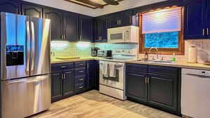 A kitchen with dark cabinets, stainless steel appliances, a microwave, a toaster, and a dishwasher. - Vacation Rental Home ~ 2 Mi to Windham Mountain! (Windham)