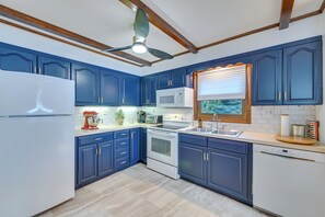 A kitchen with blue cabinets, white appliances, and a wooden ceiling. - Vacation Rental Home ~ 2 Mi to Windham Mountain! (Windham)