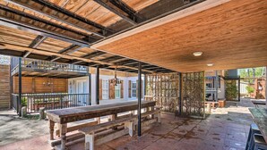 An outdoor patio area with wooden benches and a covered seating area. - Guadalupe Riverfront Studio w/ Private Balcony (Seguin)