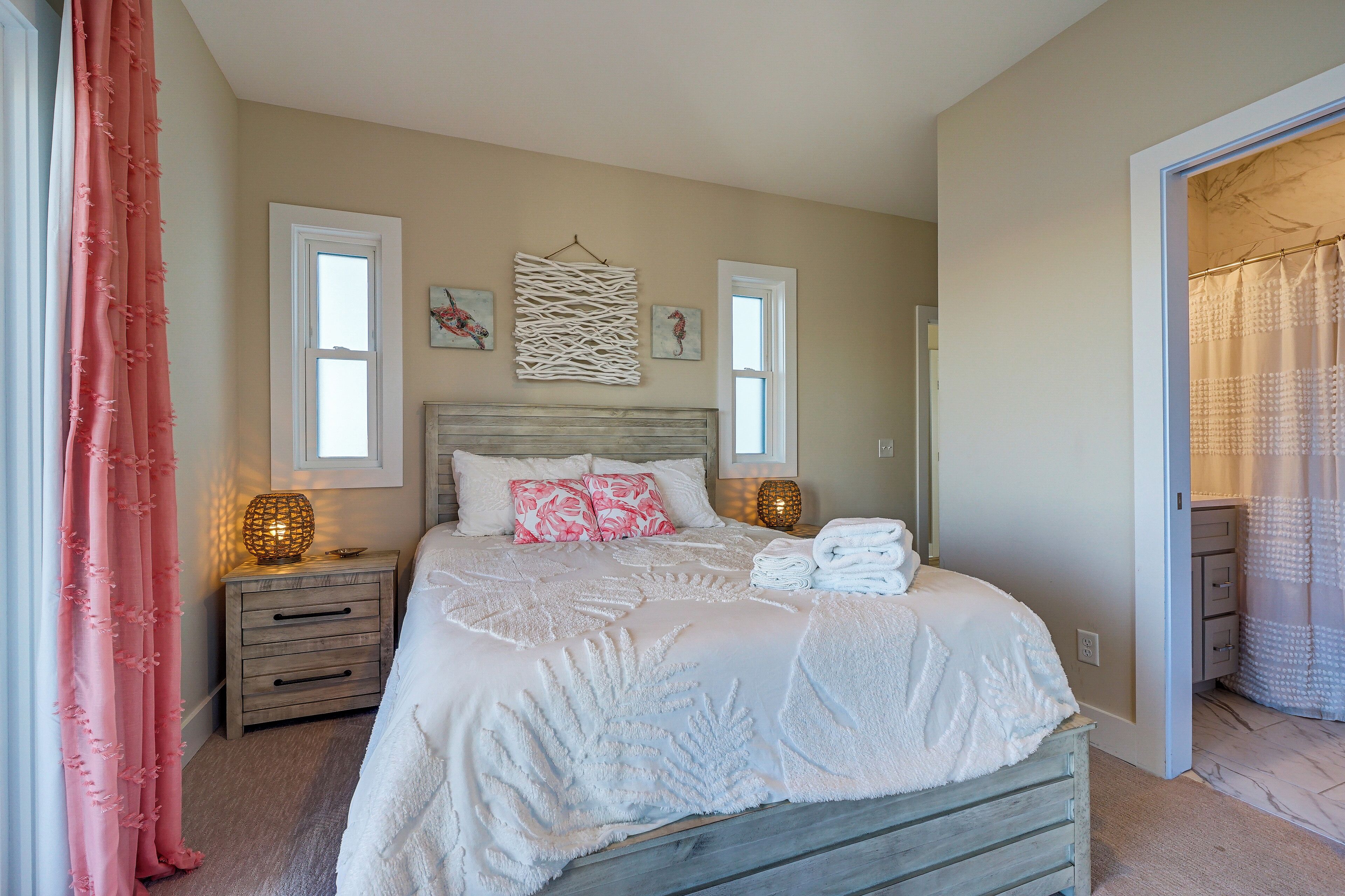 A bedroom with a bed, nightstands, and a window.