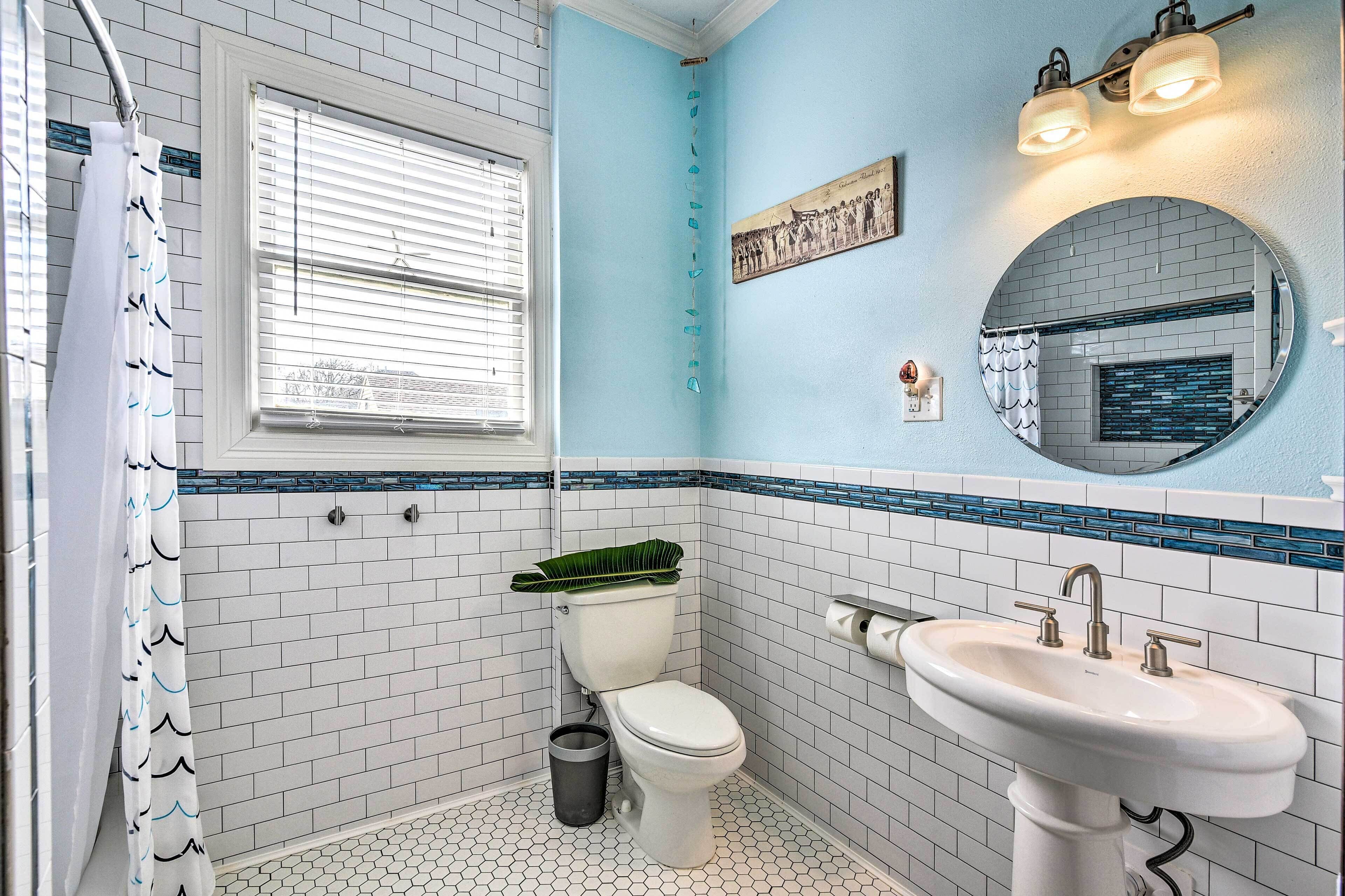 A bathroom with a toilet, sink, and a window with blinds.
