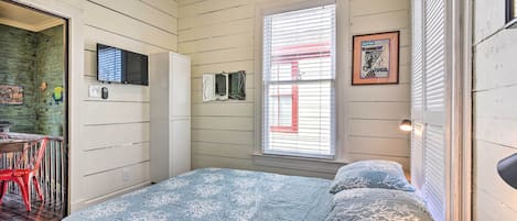 Un dormitorio con cama, escritorio y silla.