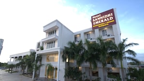 Un hotel modern amb un cartell per a l'Hotel Sannidhi Emerald.