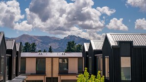 A modern building with multiple rooms, large windows, and a mountainous backdrop. - Winton Wonder - Wanaka Holiday Apartment (Wanaka)