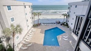 A pool area with a view of the beach and ocean. - Almost Heaven - Beautiful Oceanfront Condo with a Pool! (Murrells Inlet)