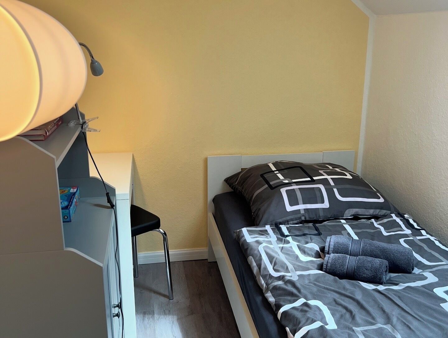Ein Schlafzimmer mit einem Bett, einem Schreibtisch und einem Sessel.