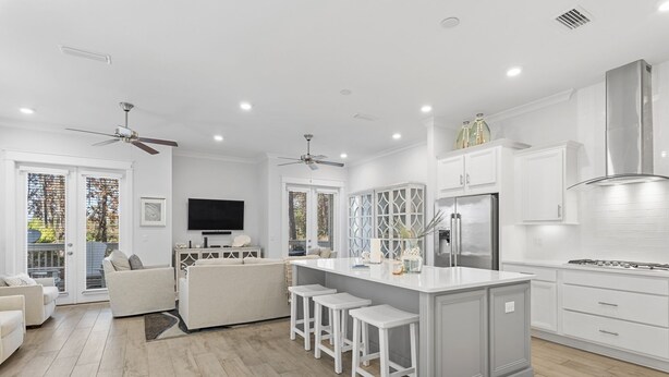 A modern kitchen with a central island, white cabinetry, and a built-in refrigerator. - Prominence Townhome with LSV and Bikes (Watersound)